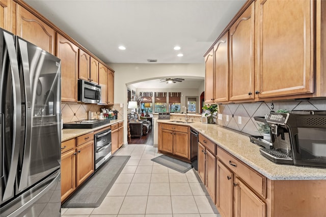 kitchen with sink, ceiling fan, light tile patterned flooring, kitchen peninsula, and stainless steel appliances