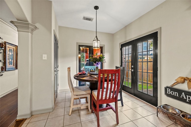 dining area with ornate columns, light tile patterned floors, and french doors