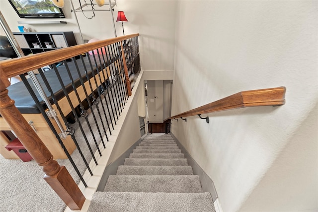 staircase featuring carpet floors and a towering ceiling