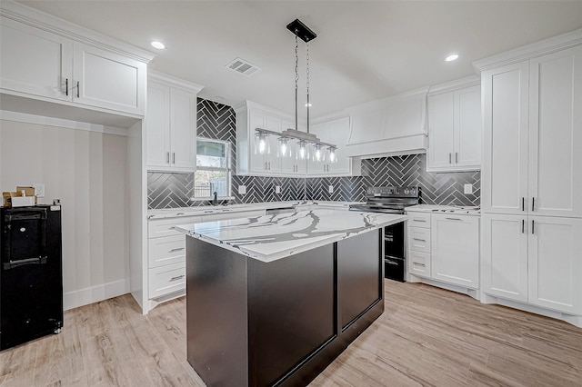 kitchen featuring pendant lighting, white cabinetry, and stainless steel range with electric cooktop