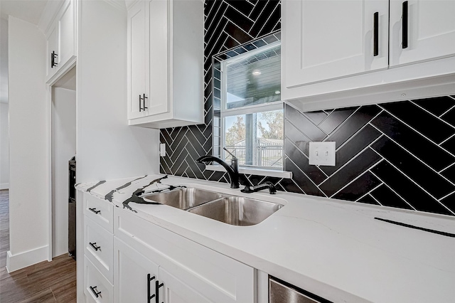 kitchen featuring sink, light stone countertops, tasteful backsplash, dark hardwood / wood-style flooring, and white cabinetry