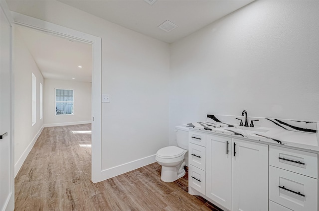 bathroom featuring vanity, wood-type flooring, and toilet