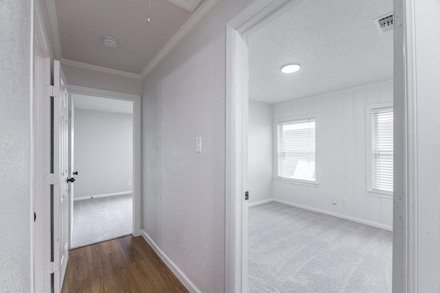 hallway featuring a textured ceiling, ornamental molding, and dark wood-type flooring