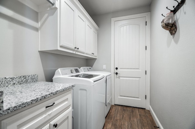 washroom with dark hardwood / wood-style flooring, cabinets, and separate washer and dryer