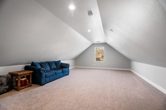 additional living space with carpet flooring, vaulted ceiling, and a textured ceiling