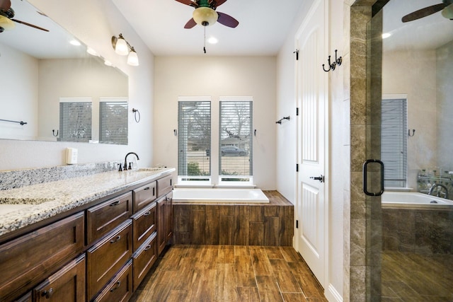 bathroom with plus walk in shower, hardwood / wood-style floors, and vanity