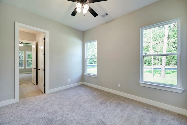 empty room featuring ceiling fan and light carpet