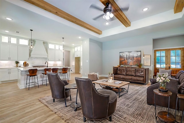 living room featuring ceiling fan, french doors, beamed ceiling, and light hardwood / wood-style floors