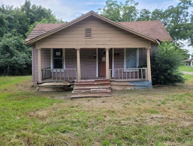 bungalow with covered porch and a front lawn