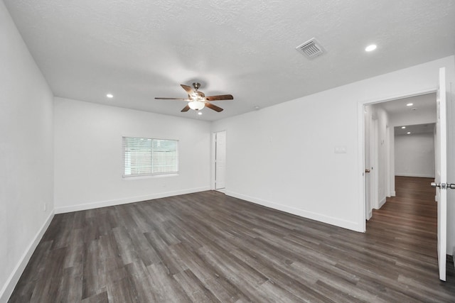 spare room with dark hardwood / wood-style flooring, ceiling fan, and a textured ceiling