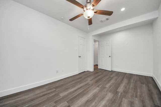 empty room with dark wood-type flooring and ceiling fan