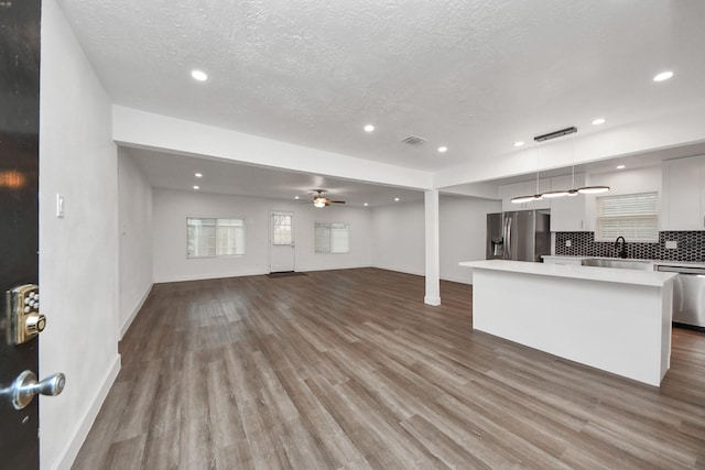 living room with sink, hardwood / wood-style flooring, a textured ceiling, and ceiling fan