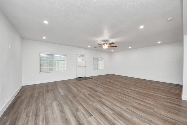 unfurnished living room featuring ceiling fan, a textured ceiling, and light wood-type flooring