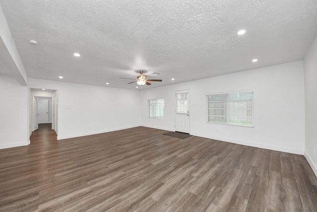 unfurnished living room featuring ceiling fan, a textured ceiling, and dark hardwood / wood-style flooring