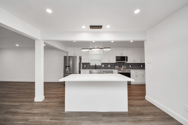 kitchen featuring pendant lighting, white cabinetry, sink, a center island, and stainless steel appliances