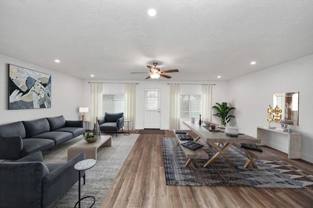 living room featuring ceiling fan, hardwood / wood-style floors, and a textured ceiling