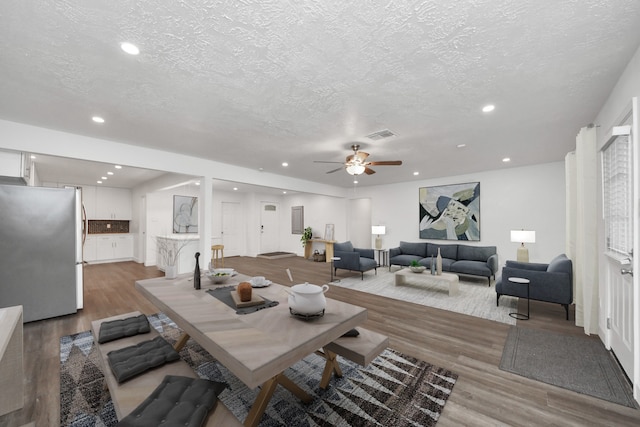 living room featuring hardwood / wood-style floors, a textured ceiling, and ceiling fan