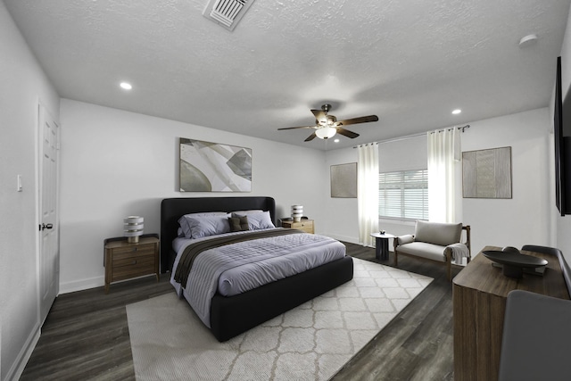 bedroom with hardwood / wood-style flooring, ceiling fan, and a textured ceiling