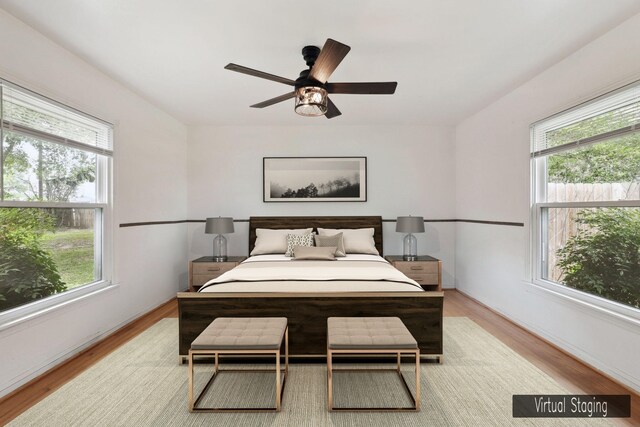 bedroom with multiple windows, ceiling fan, and light hardwood / wood-style floors