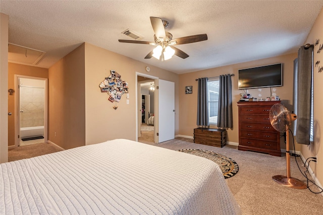 bedroom featuring a textured ceiling, light colored carpet, ensuite bath, and ceiling fan