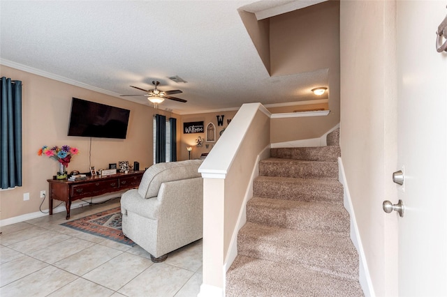 stairs featuring a textured ceiling, tile patterned floors, ceiling fan, and ornamental molding