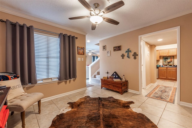 sitting room featuring a textured ceiling, ceiling fan, ornamental molding, and light tile patterned flooring