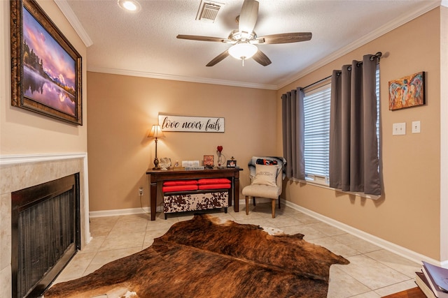 living area featuring a textured ceiling, ceiling fan, ornamental molding, and light tile patterned flooring