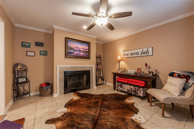 tiled living room with ceiling fan, crown molding, a textured ceiling, and a tiled fireplace