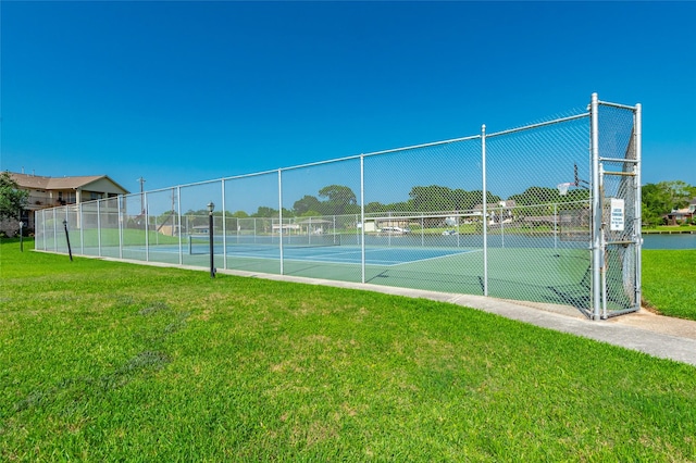 view of tennis court featuring a lawn