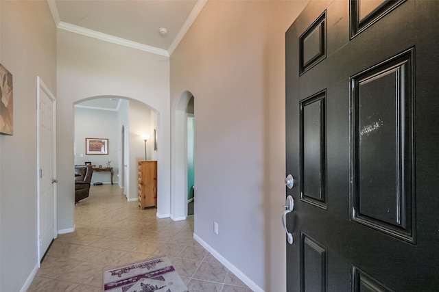 tiled entryway featuring a towering ceiling and crown molding