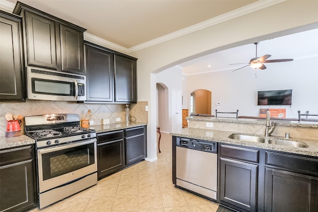 kitchen featuring sink, tasteful backsplash, appliances with stainless steel finishes, light tile patterned floors, and ornamental molding