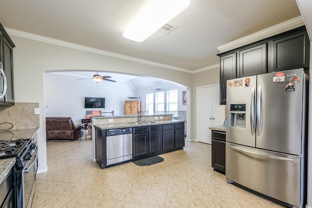 kitchen with stainless steel appliances, light stone counters, ceiling fan, and sink