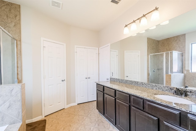 bathroom with vanity, tile patterned floors, and a shower with door