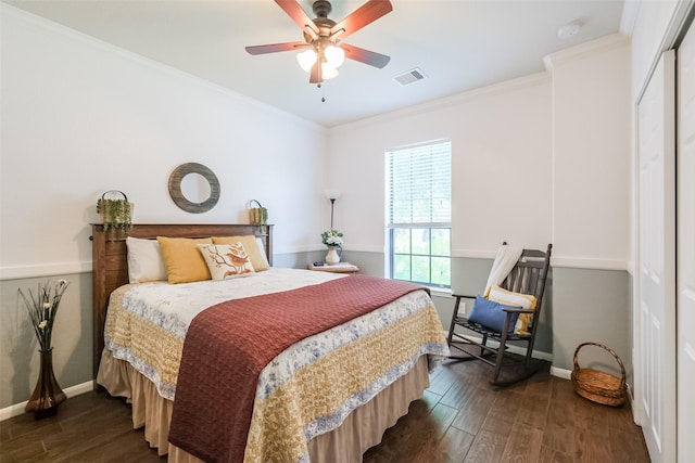 bedroom with crown molding, ceiling fan, a closet, and dark wood-type flooring