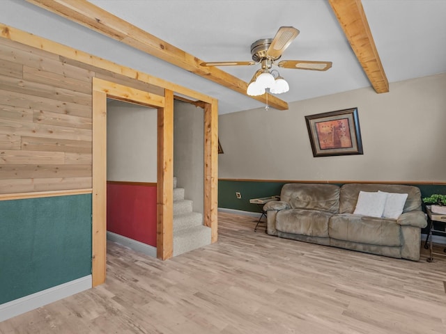 living room with ceiling fan, beam ceiling, and light hardwood / wood-style flooring