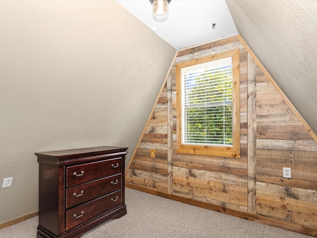 additional living space featuring light carpet, wood walls, and lofted ceiling