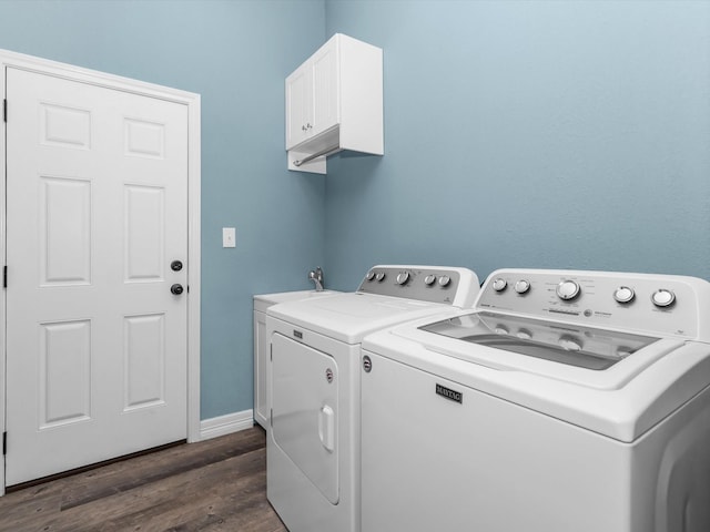 washroom featuring dark hardwood / wood-style flooring, cabinets, and independent washer and dryer