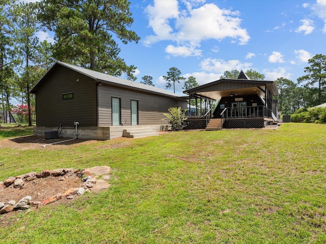 back of house featuring a lawn, ceiling fan, and a porch