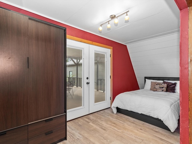 bedroom featuring access to exterior, french doors, track lighting, and light hardwood / wood-style flooring