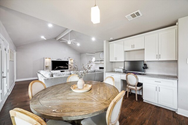 dining area featuring lofted ceiling with beams, ceiling fan, dark hardwood / wood-style flooring, and built in desk