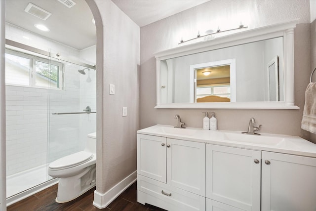 bathroom with vanity, an enclosed shower, and toilet