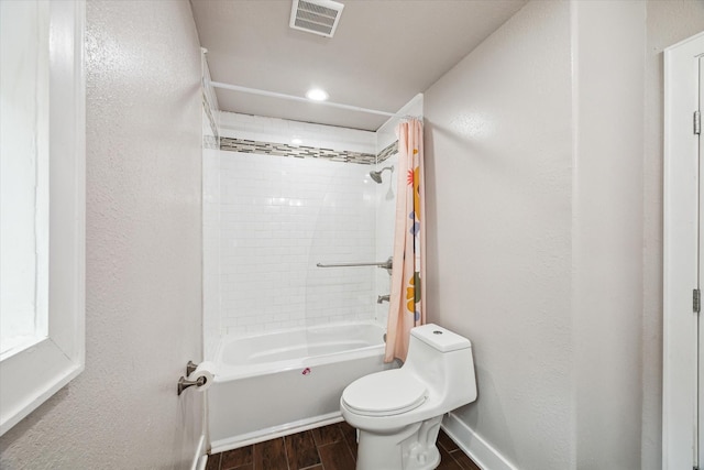 bathroom featuring toilet and tiled shower / bath