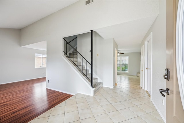 stairs featuring a wealth of natural light, ceiling fan, and tile patterned flooring