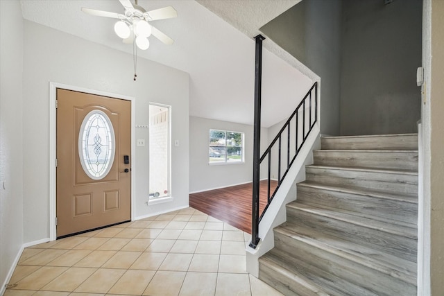 entryway featuring ceiling fan, light tile patterned floors, and a textured ceiling