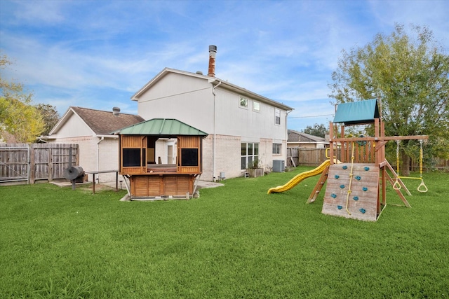 back of property with a gazebo, a yard, a playground, and cooling unit