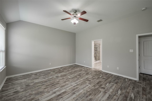 spare room with ceiling fan, dark hardwood / wood-style floors, and vaulted ceiling