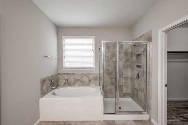 bathroom featuring tile patterned flooring and shower with separate bathtub