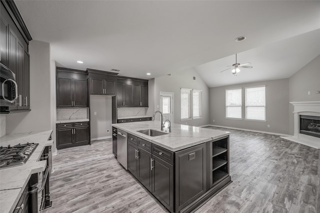 kitchen featuring a high end fireplace, sink, vaulted ceiling, ceiling fan, and stainless steel appliances