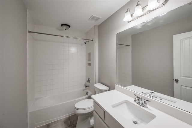 full bathroom featuring tile patterned flooring, vanity, tiled shower / bath combo, and toilet