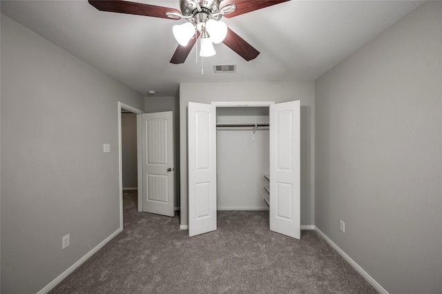 unfurnished bedroom with dark colored carpet, ceiling fan, and a closet